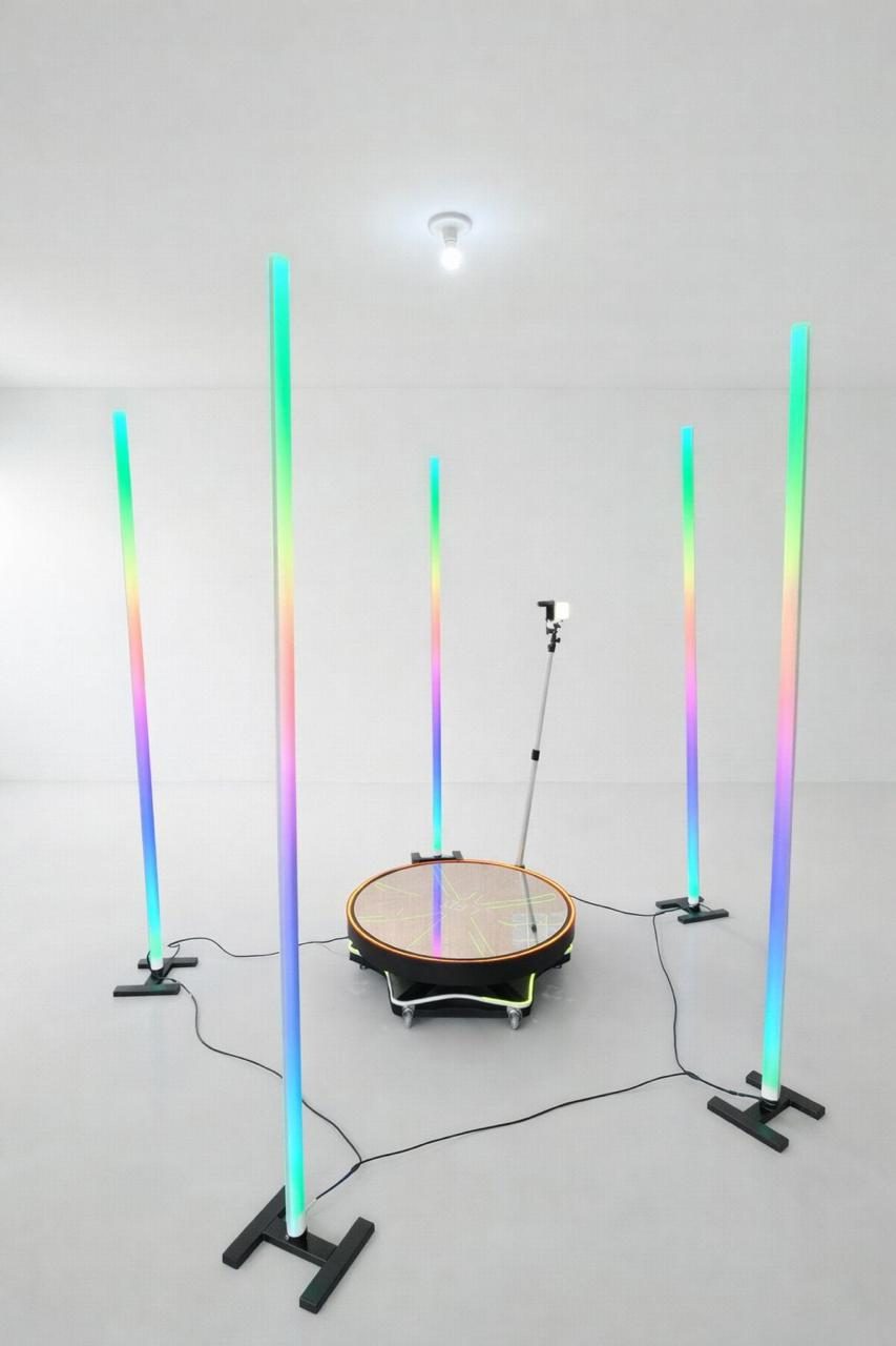 Plataforma 360 com cinco colunas de luz coloridas ao redor da plataforma giratória